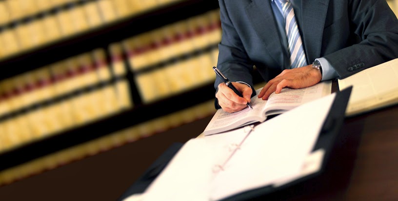 A lawyer writing in a notebook representing the legal services of the Law Offices of Jerod Gunsberg in Los Angeles, CA